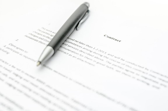 Close-up of a contract and a pen. Focus on a contract sign.
