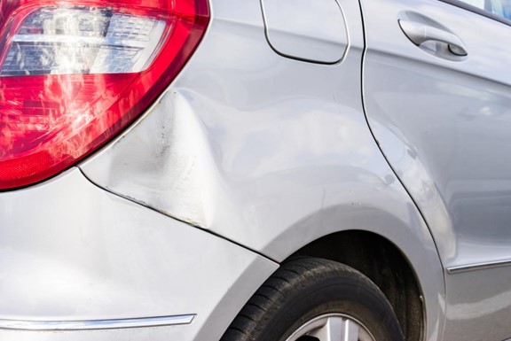 A car with a dent on the fender.