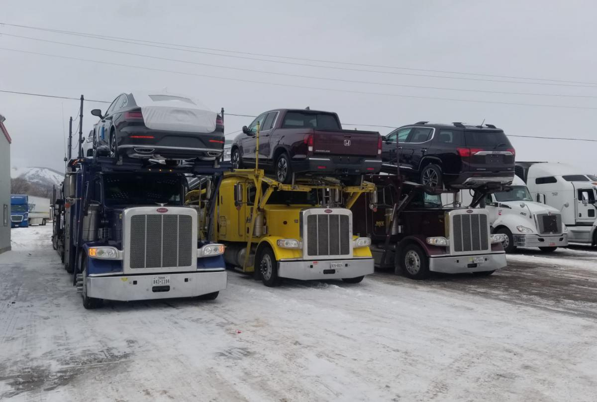Vehicle transport service carriers parked in the snow.