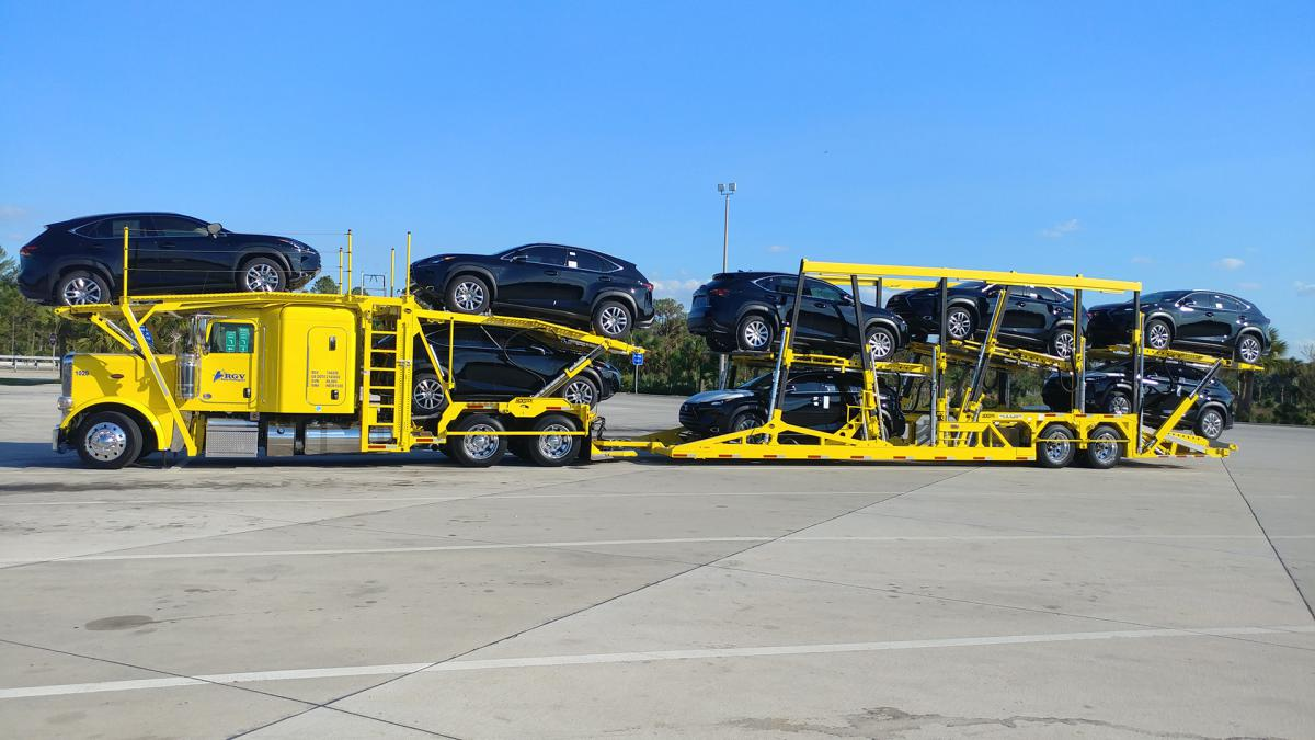 Cars being transported via trucks to different locations.