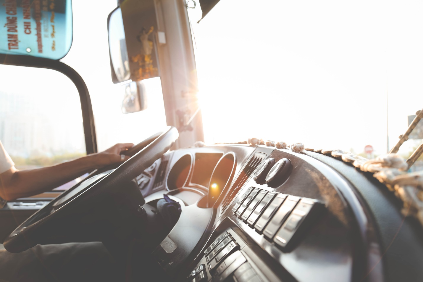 A driver’s hand on a truck’s steering wheel